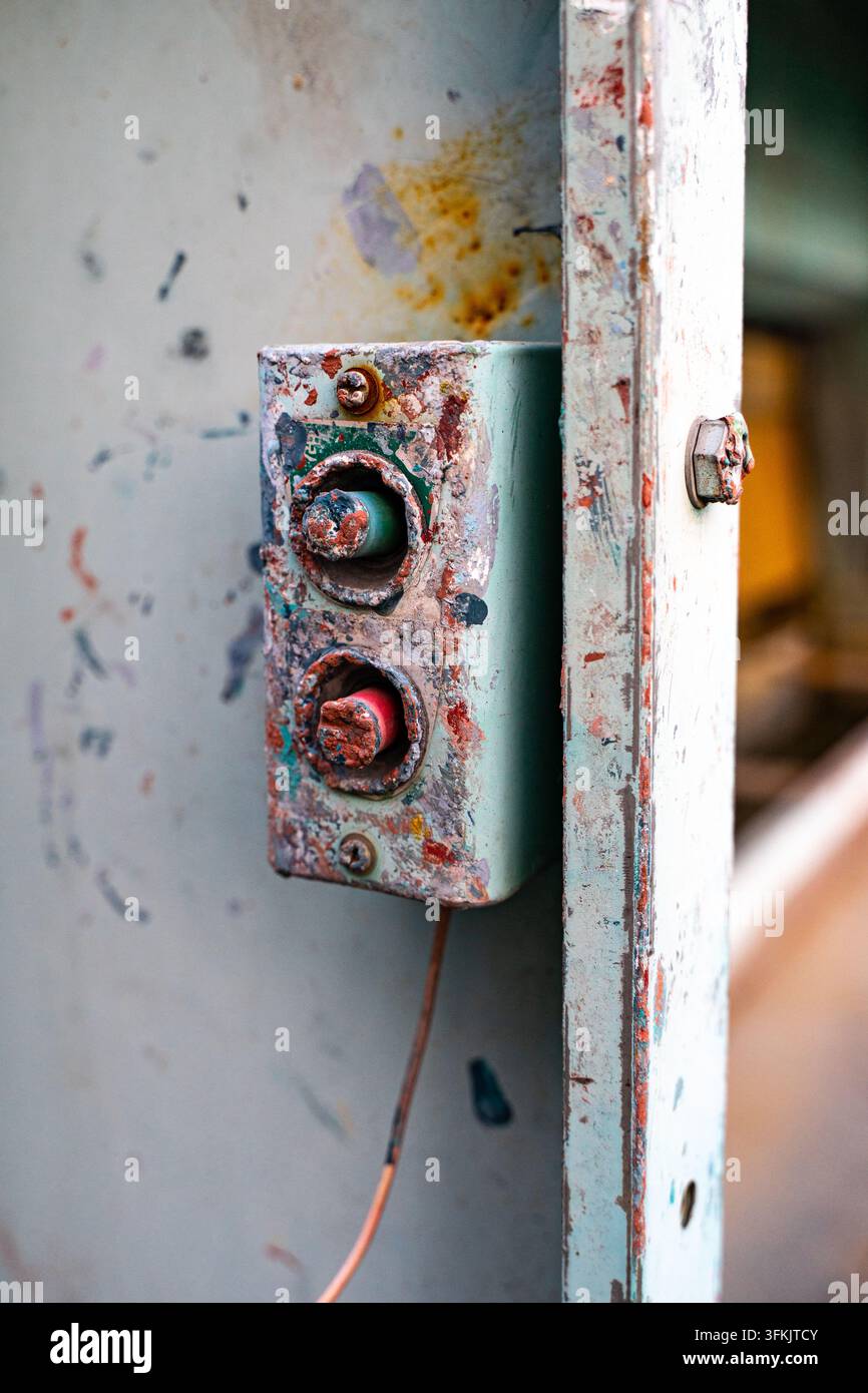 Old push button switch mounted on electrical distribution cabinet Stock Photo