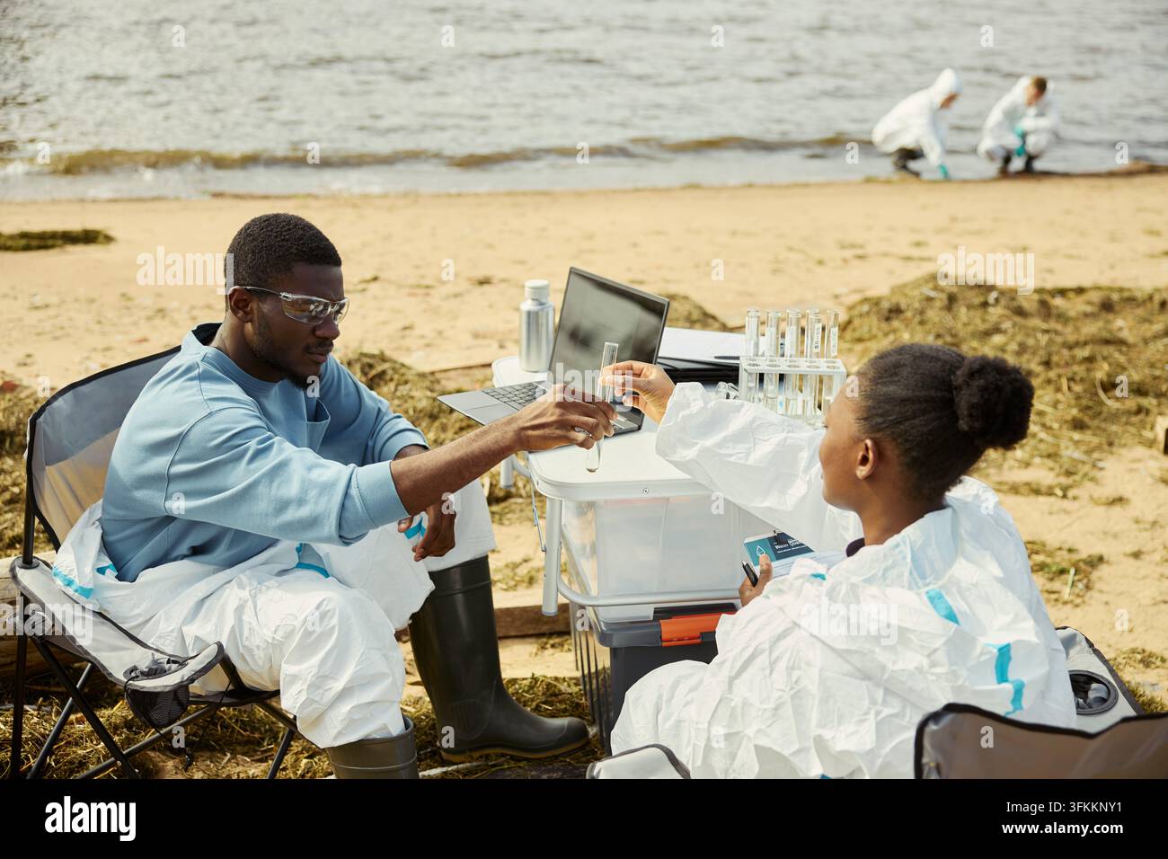 Black Ecologists Analyzing Water Samples during Field Research Stock Photo