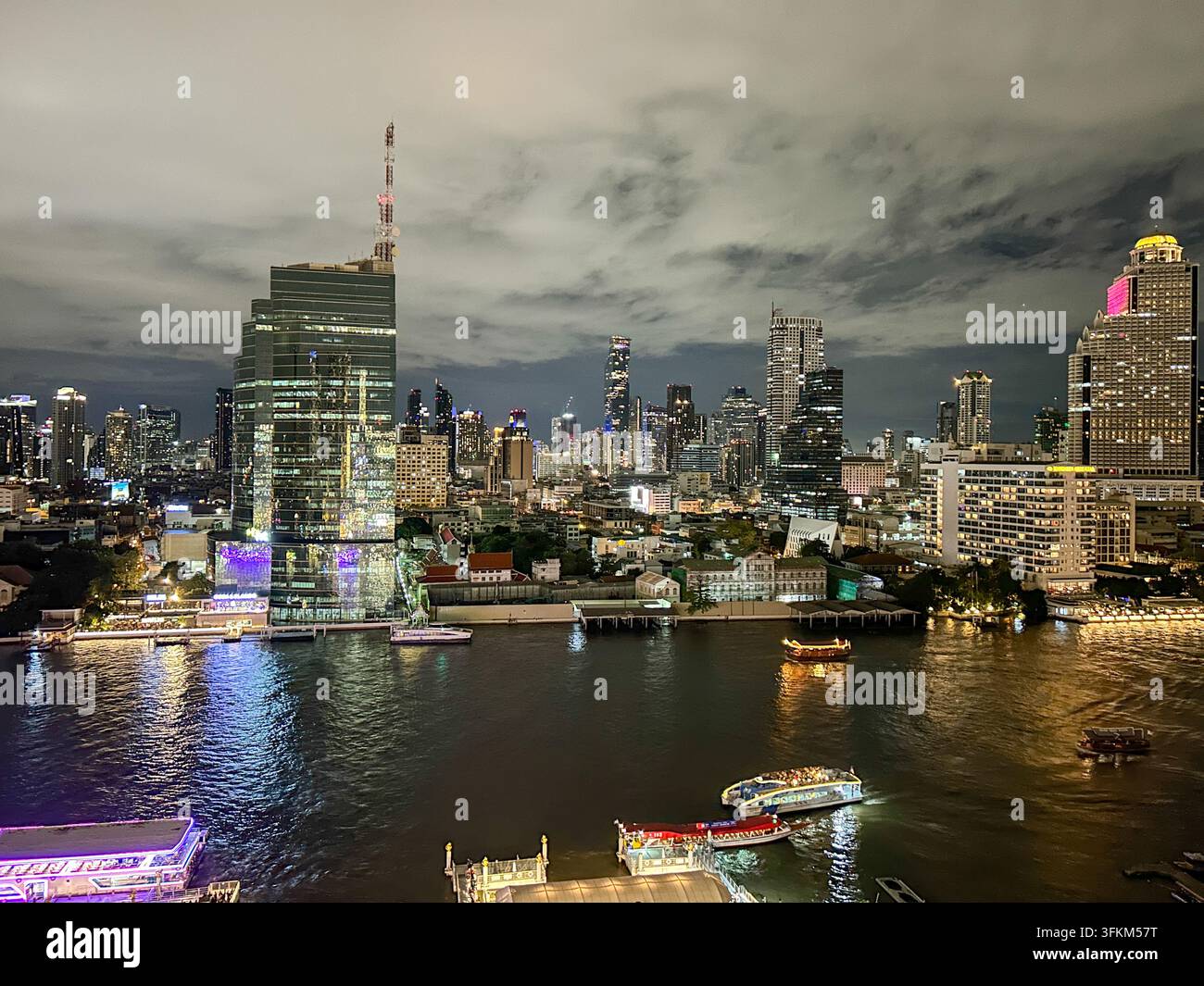 Night view of Bangkok skyline and illuminated high-rise buildings along ...