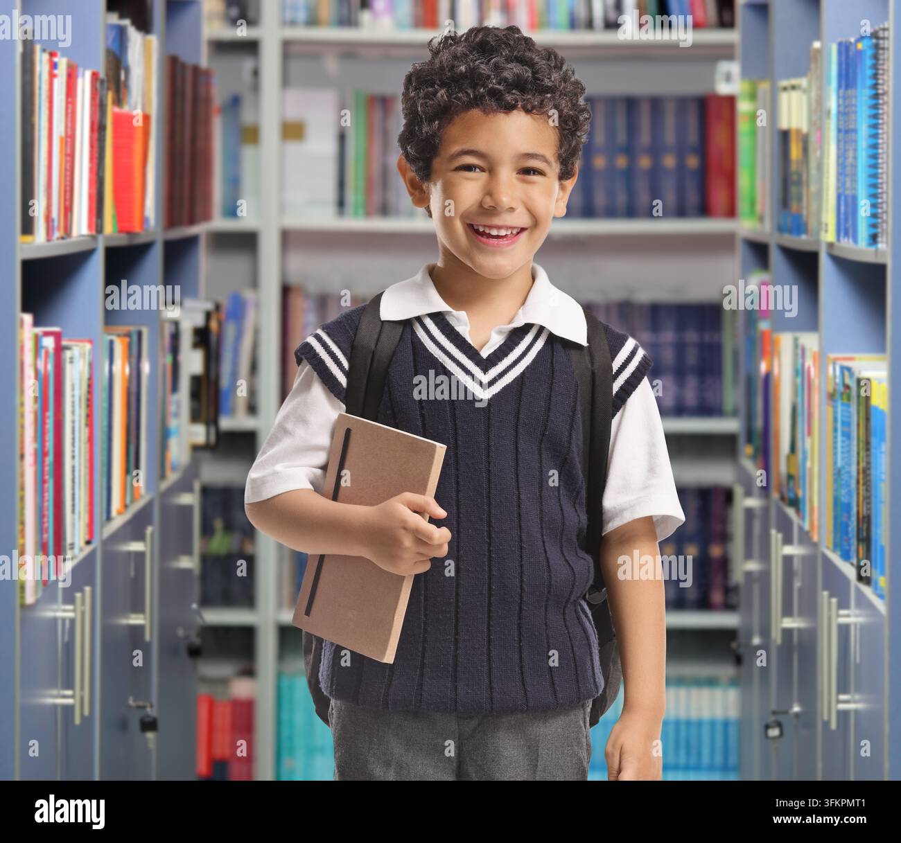 Smiling schoolboy standing in a library Stock Photo