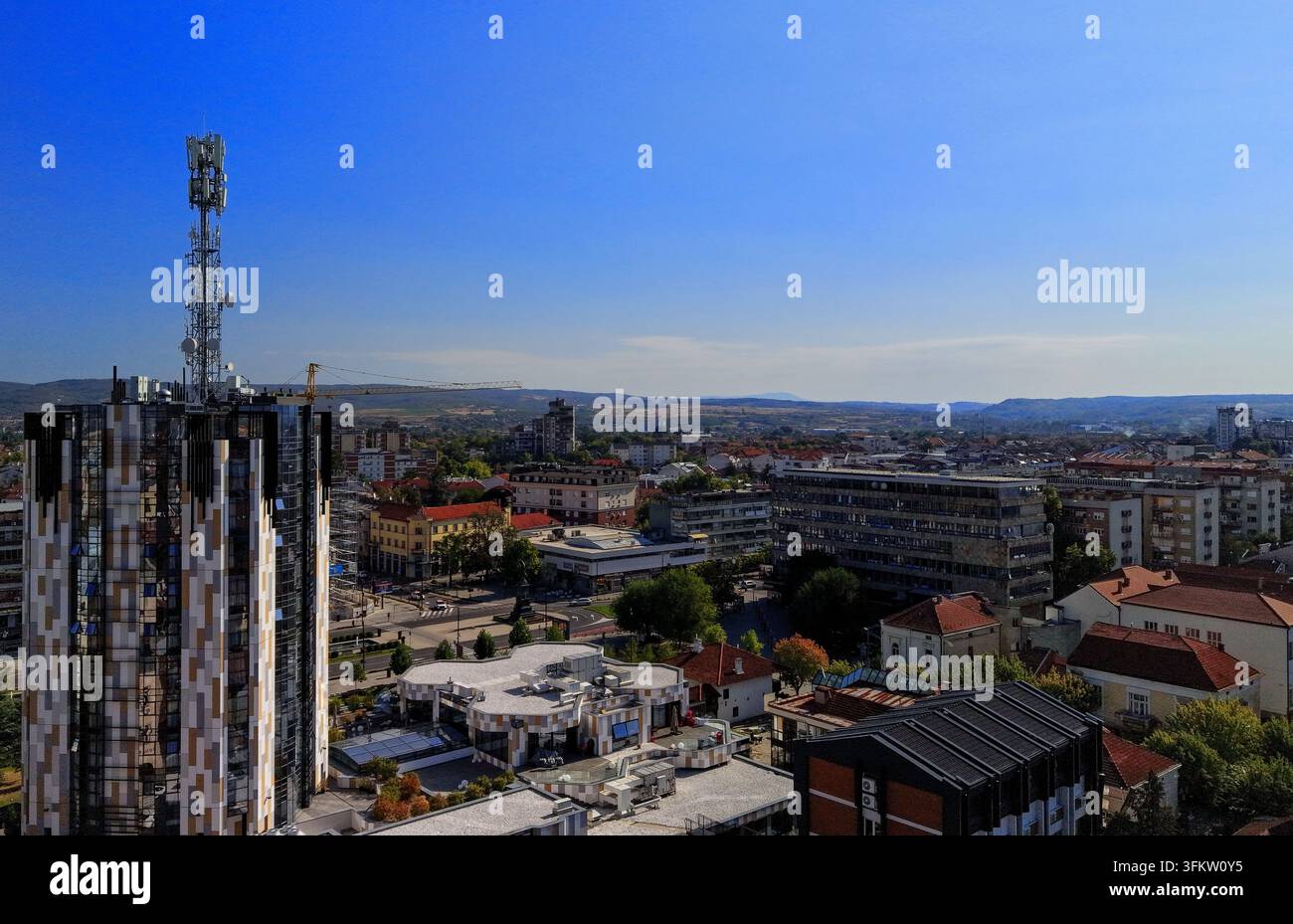Aerial view of a modern high-rise building with a telecommunications ...