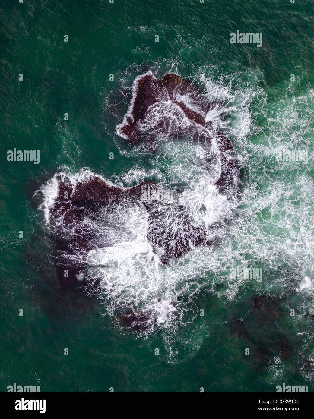Aerial View Rocks Aerial view of dark rocks in the turquoise Mediterranean Sea with white ...