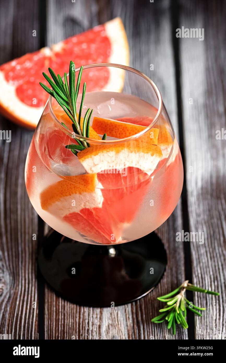 Close-up of a refreshing drink with grapefruit and rosemary in a glass ...