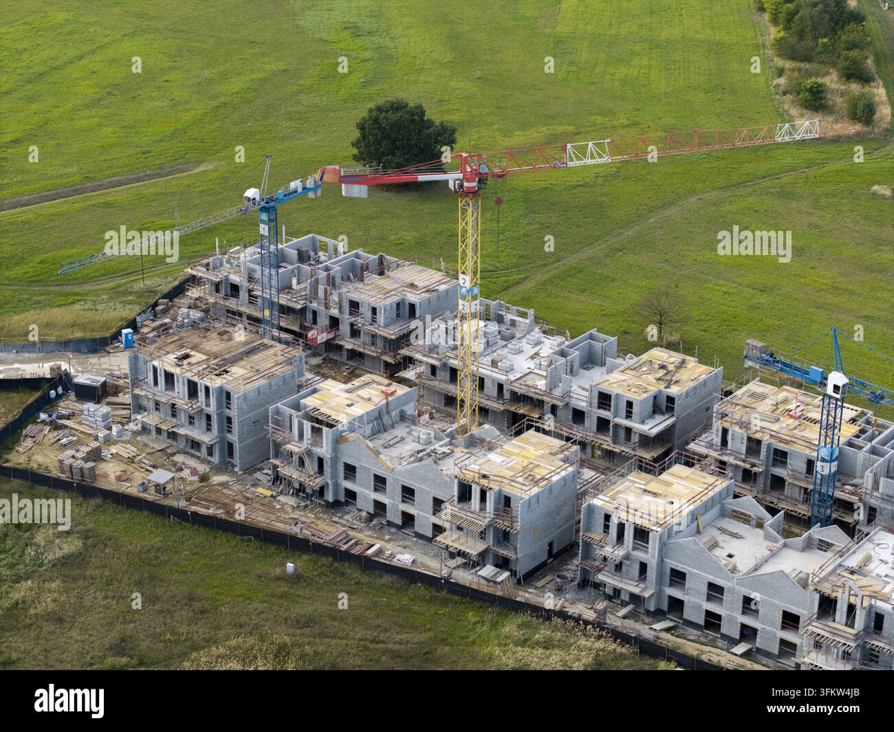Aerial view of a residential construction site with tower cranes and ...