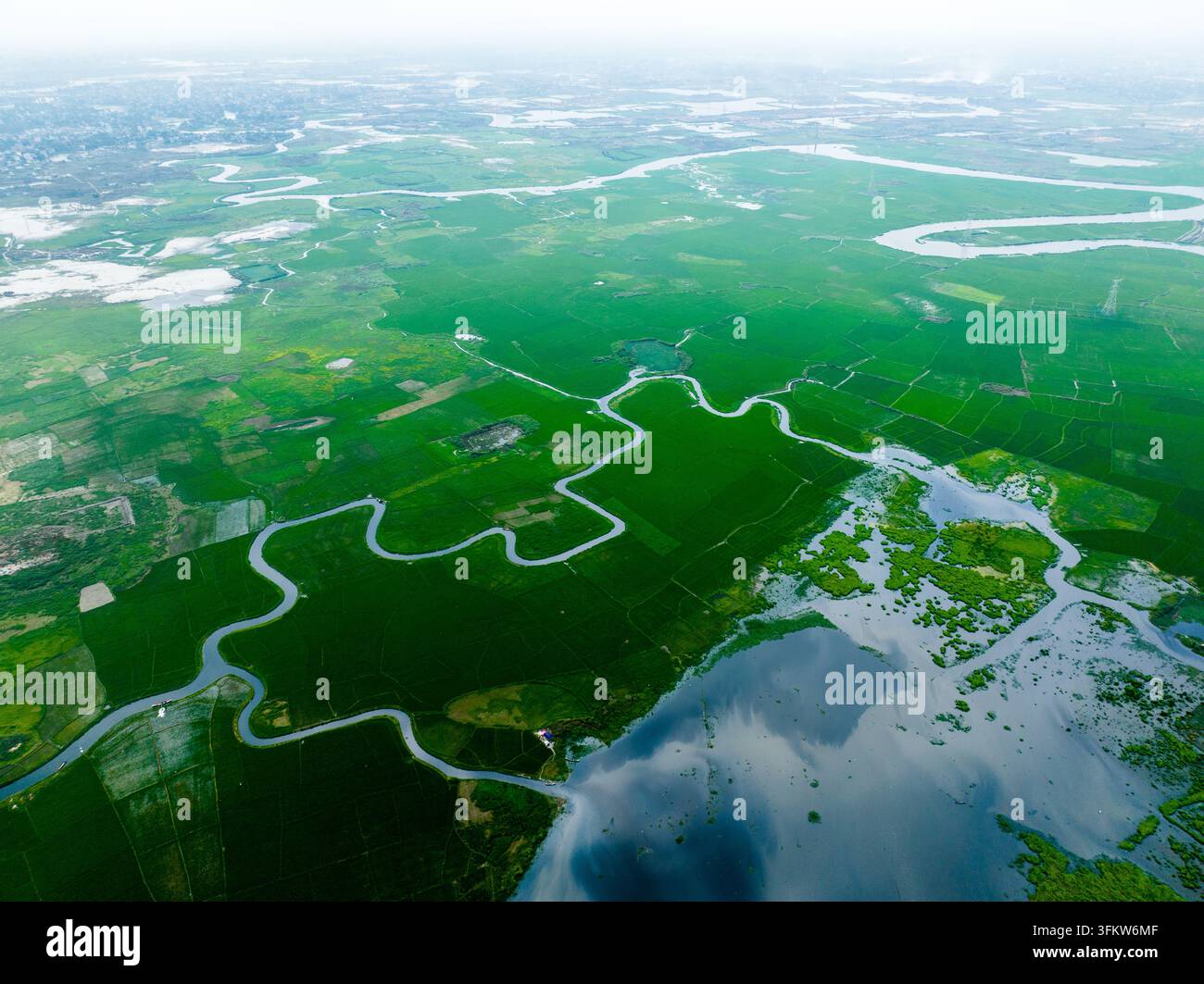 Aerial view of the winding river flowing through lush green ...