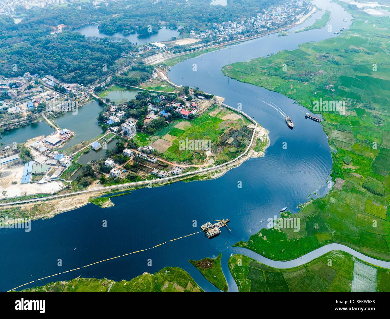 Aerial view of a winding river flowing through lush green agricultural ...