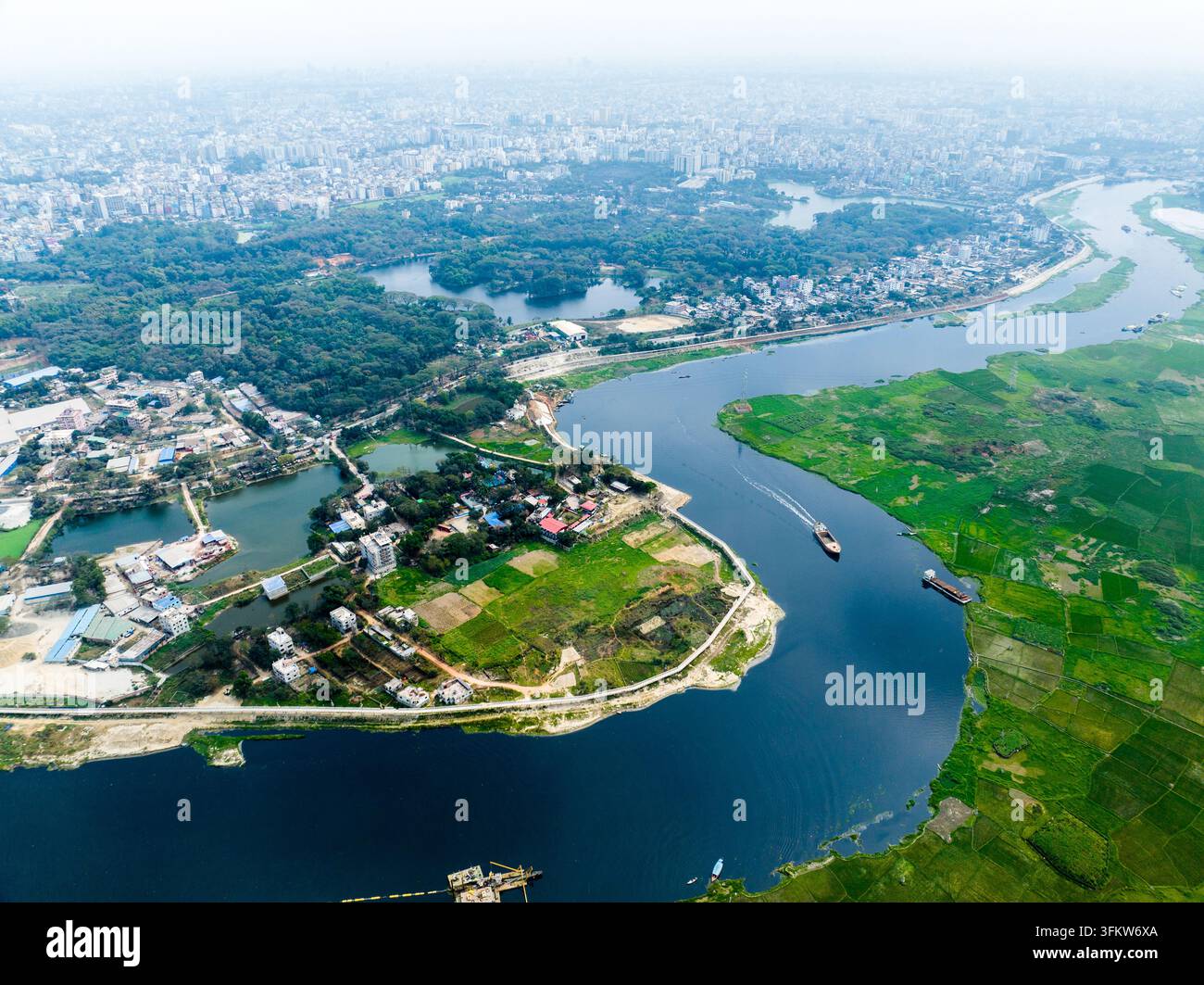Aerial view of a winding river flowing through lush green fields and ...