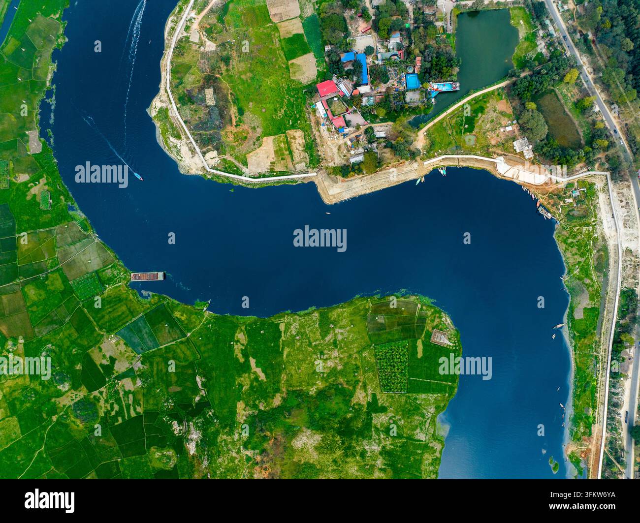 Aerial view of a winding river flowing through lush green agricultural ...