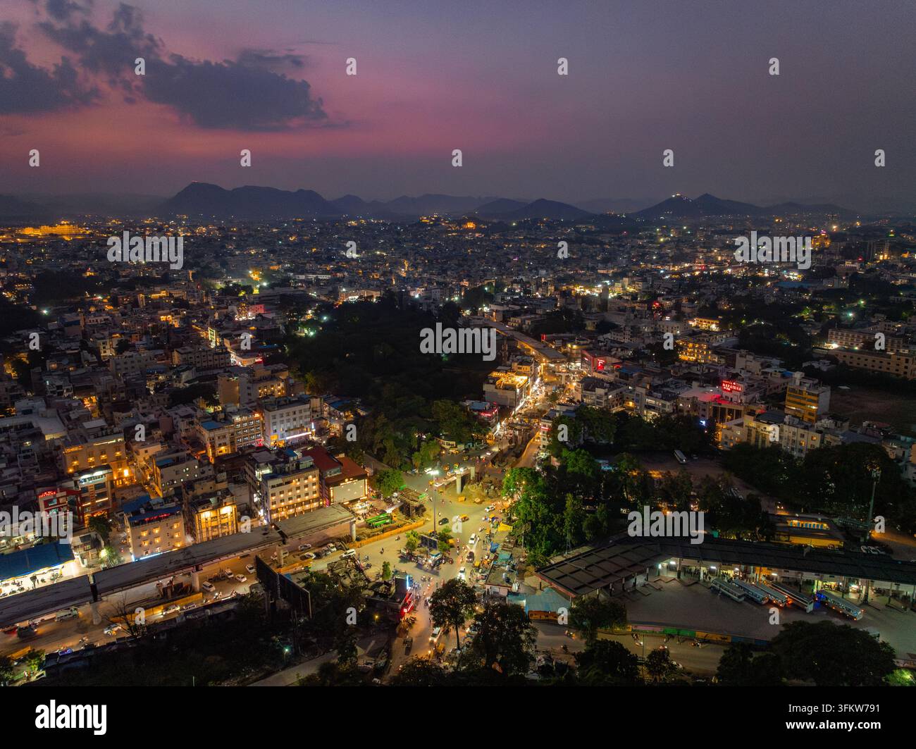 Aerial view of the illuminated cityscape at dusk, featuring dense urban ...
