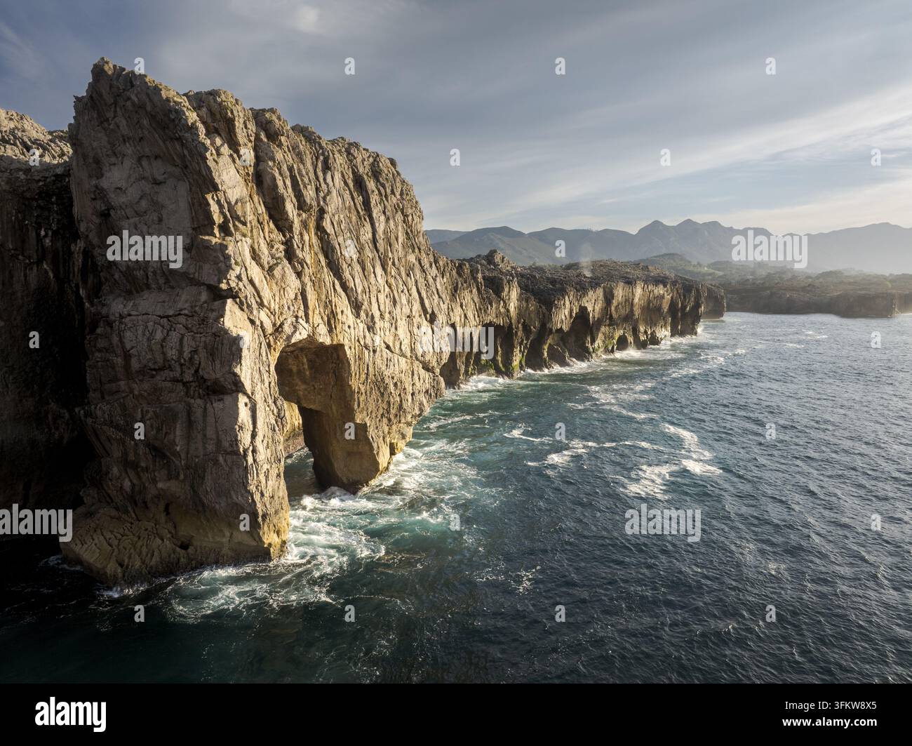 Aerial view of the rugged coastal cliffs and natural stone arch ...