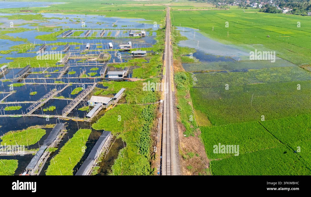 Aerial view of Lake Rawa Pening with a railway track dividing the water ...