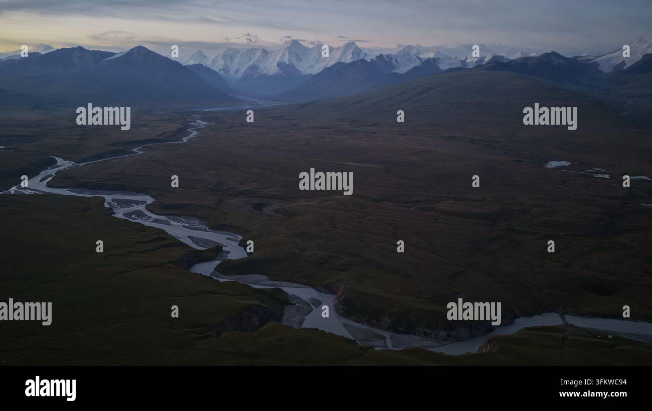 Aerial view of Engilchek Glacier with a winding river flowing through ...