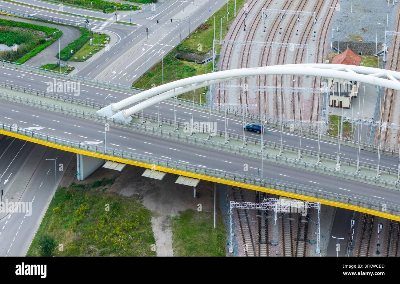 Aerial view of the modern arch bridge spanning over railway tracks and ...