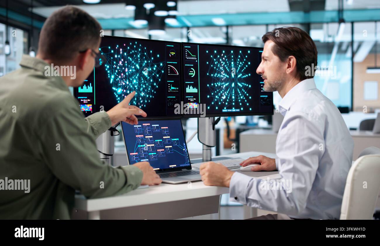 Data Scientist And Engineer Collaborate On Laptop Using AI Tools Together. Stock Photo