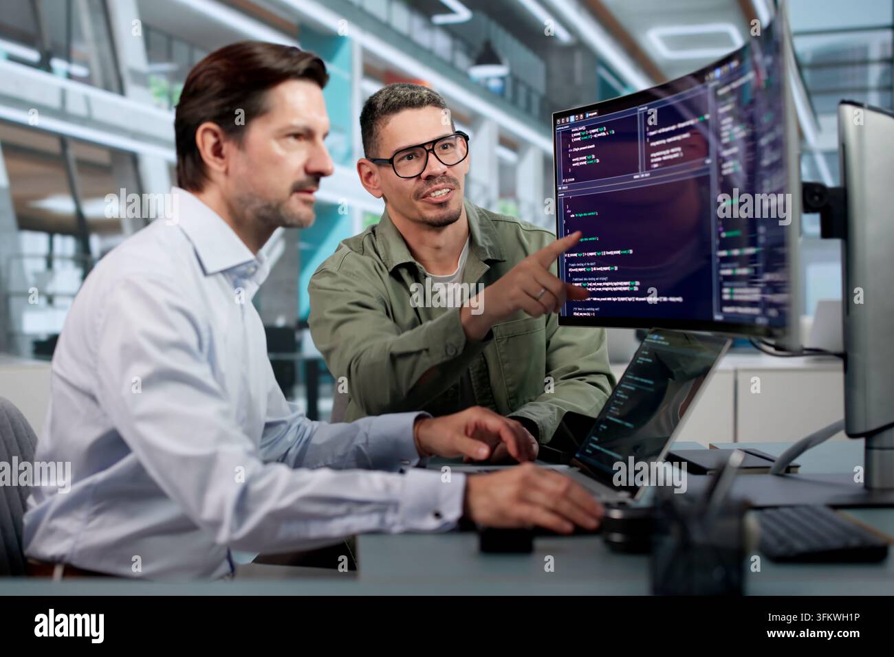 Software Engineer Carefully Reviews Code On Laptop To Build Secure Platform. Stock Photo