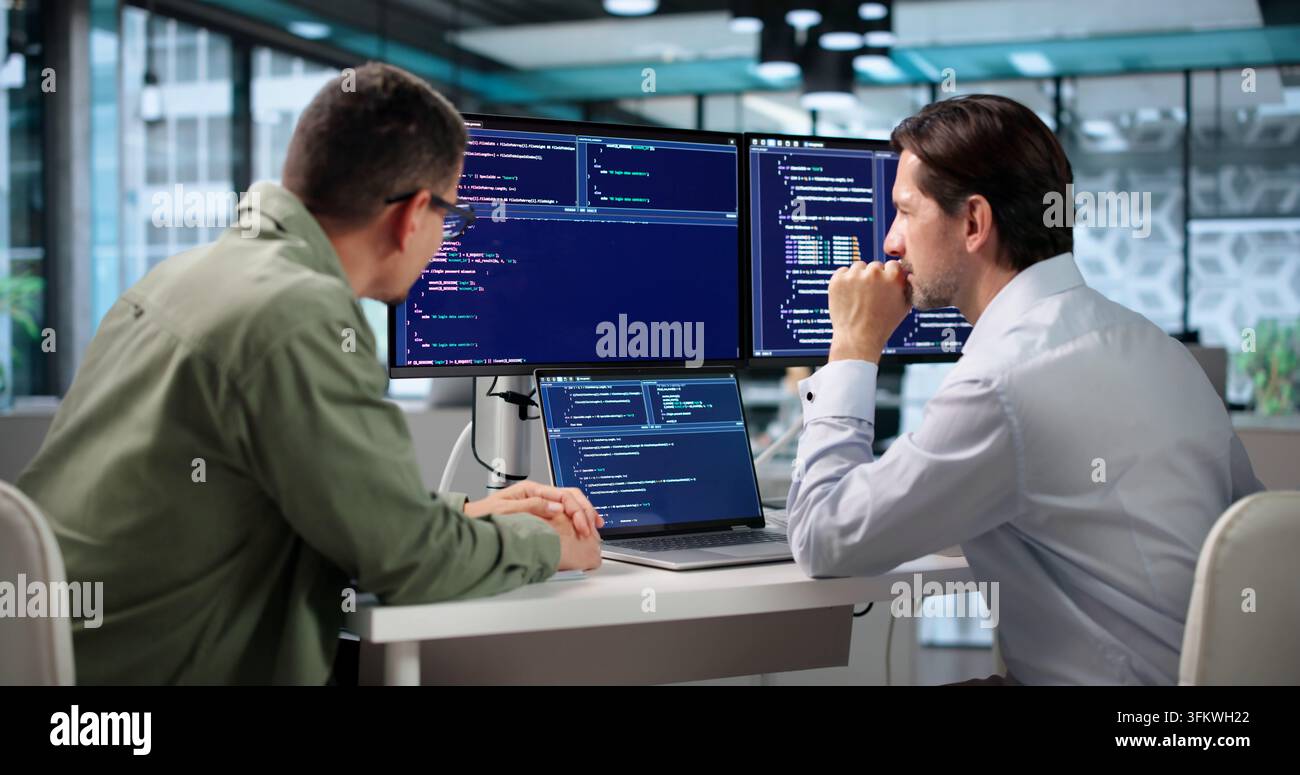 Software Engineer Coding Secure Algorithms While Collaborating At Desk. Stock Photo