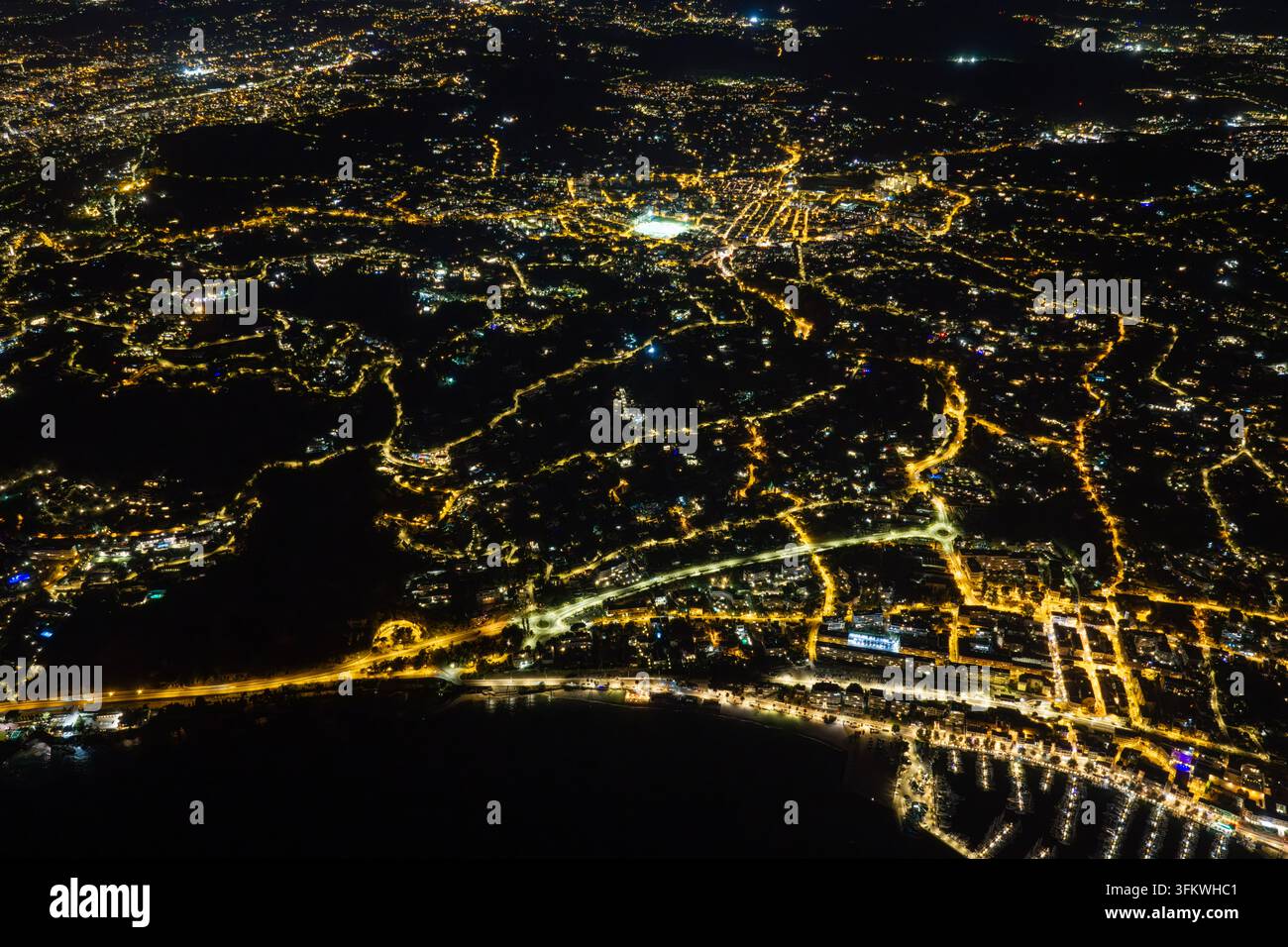Aerial view of the illuminated city of Antibes at night, showing ...