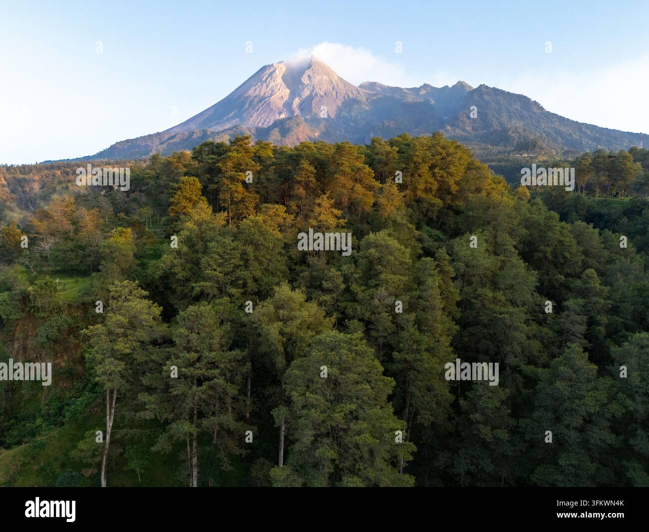 Aerial view of the majestic Mount Merapi volcano rising above a dense ...