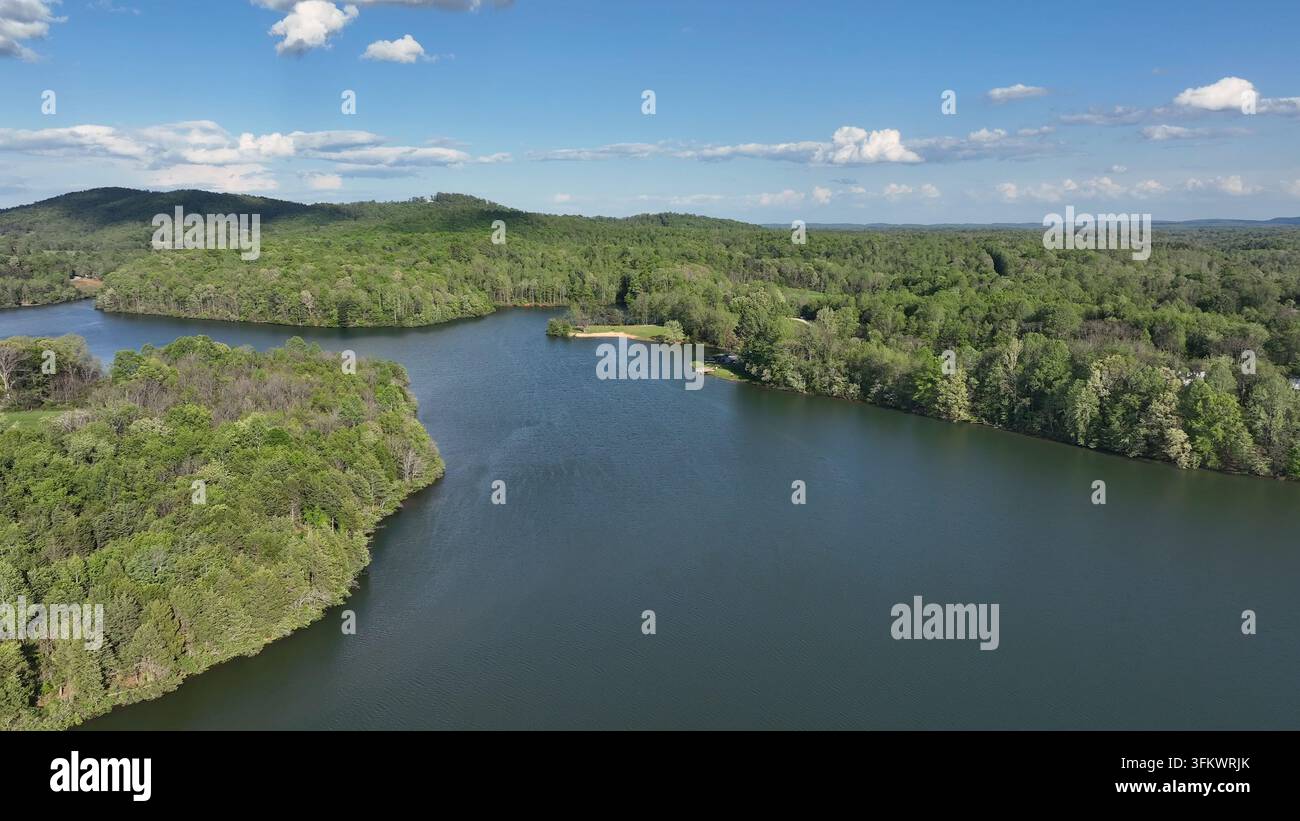 Aerial view of Mill Creek Lake surrounded by lush green forests under a ...