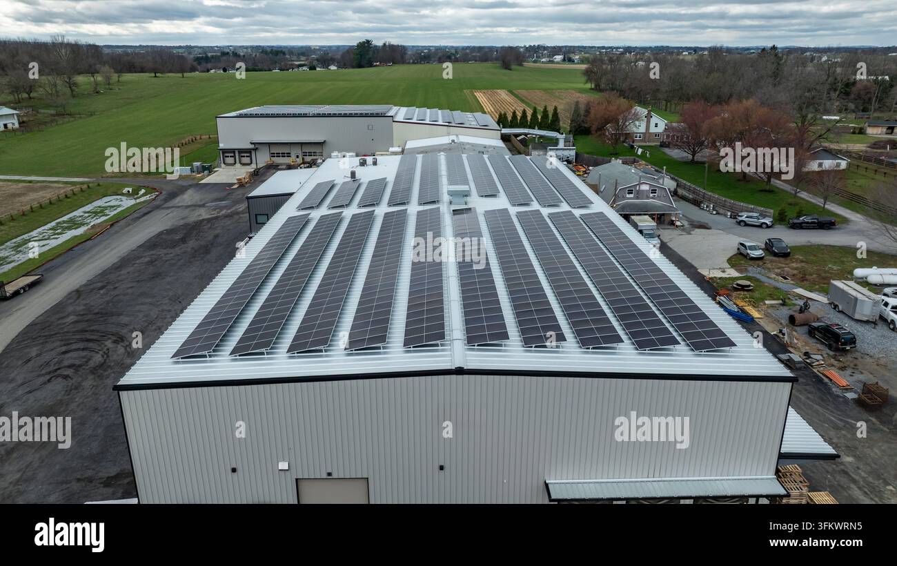 Aerial view of a large warehouse building featuring extensive solar ...