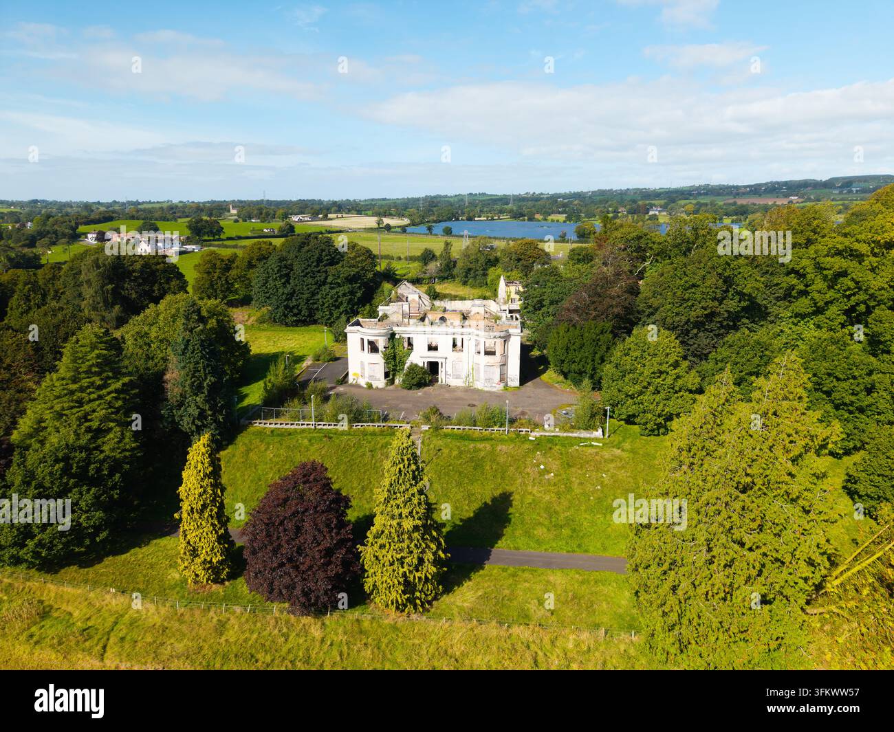 Aerial view of a derelict mansion surrounded by overgrown trees and ...