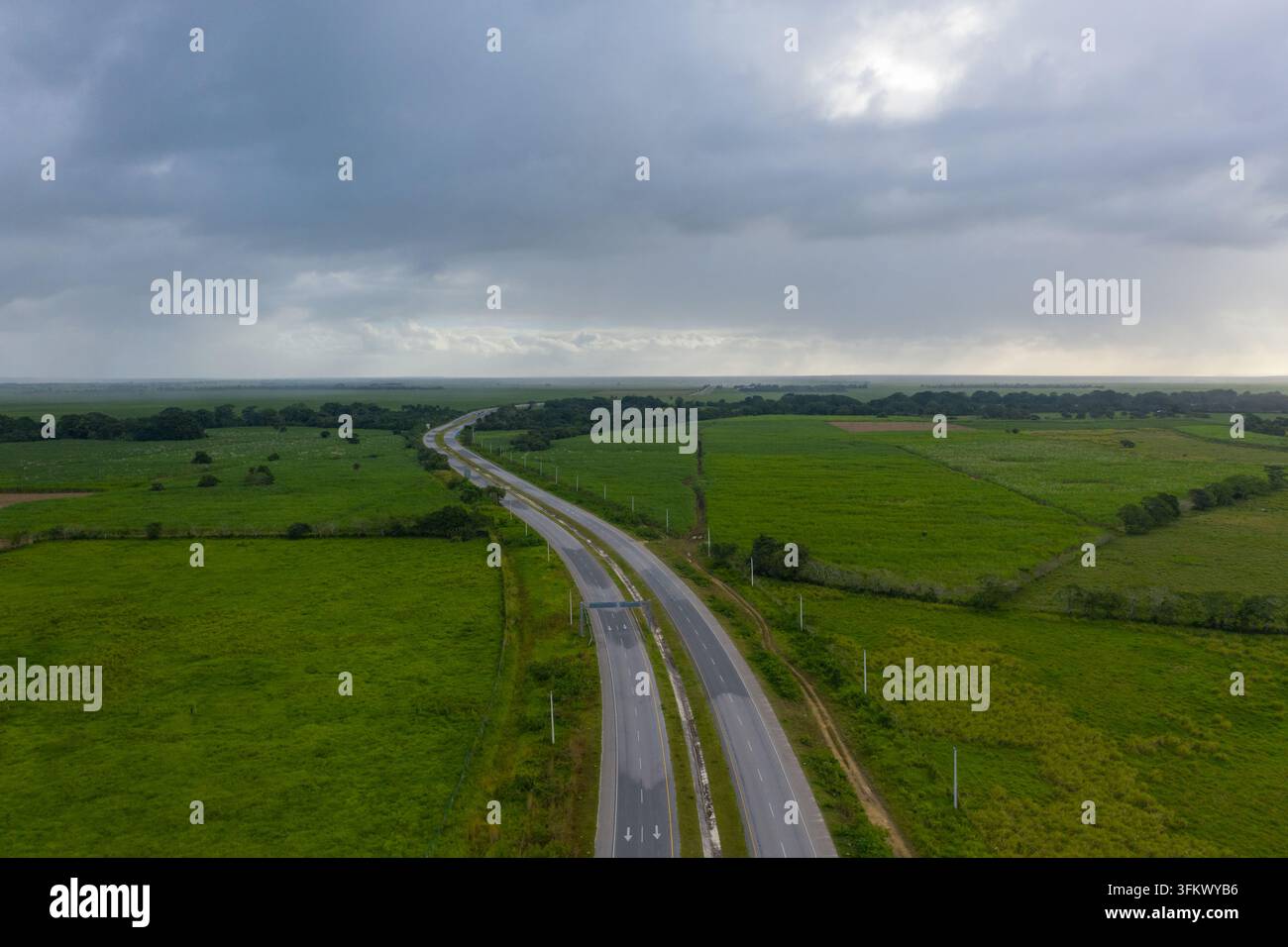 Aerial view of a highway stretching through lush green fields and ...