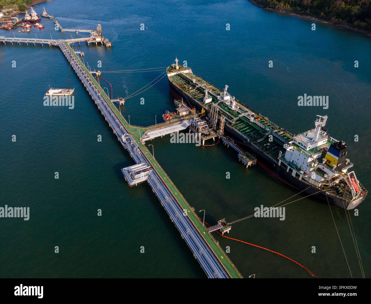Aerial view of a large oil tanker docked at an industrial pier in a ...