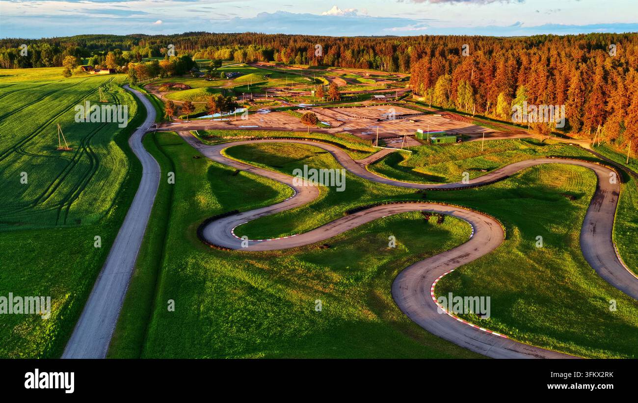 Aerial view of a winding go-kart track surrounded by lush green grass ...