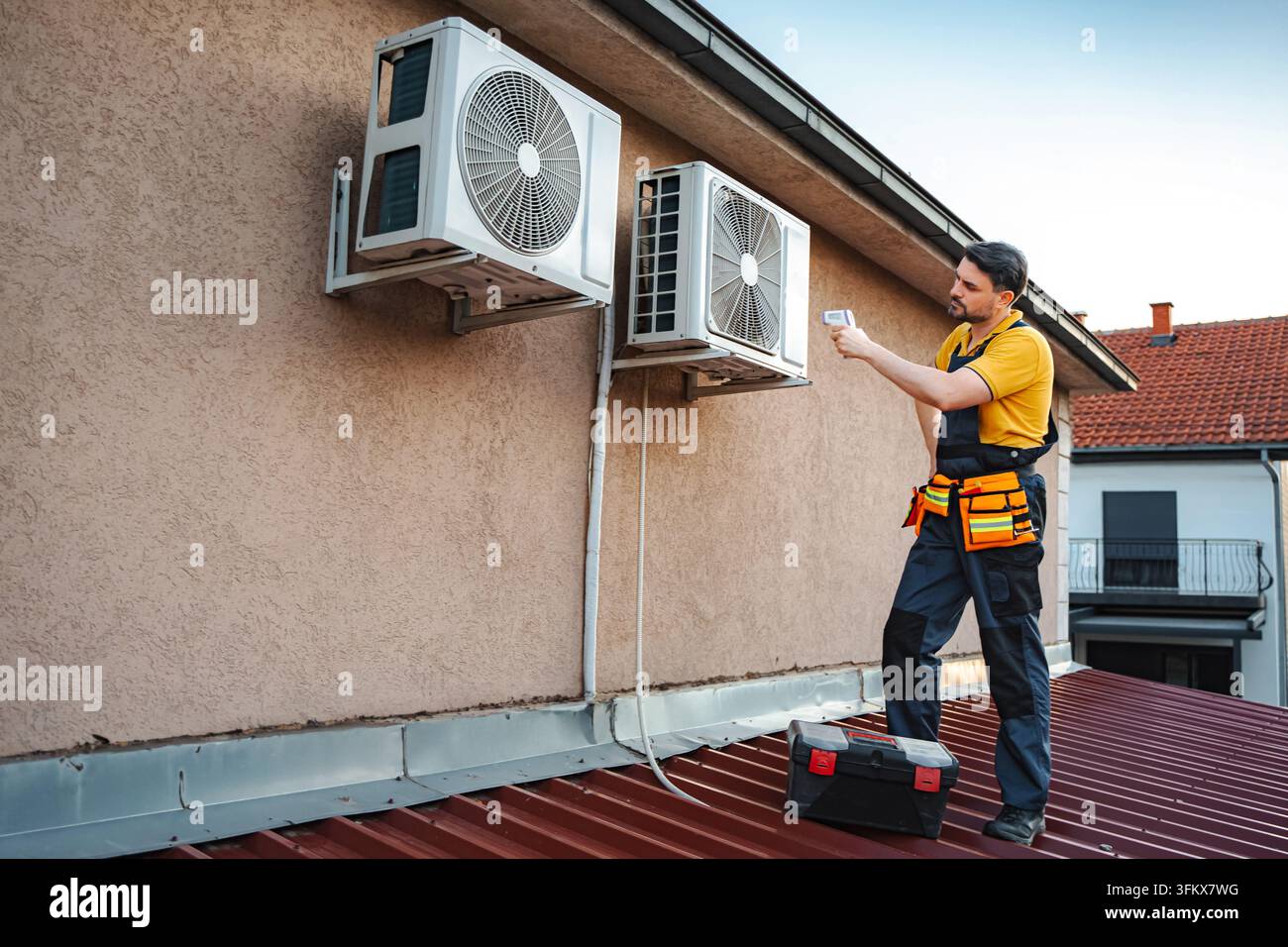 Hvac technician checking outdoor air conditioning unit temperature Stock Photo