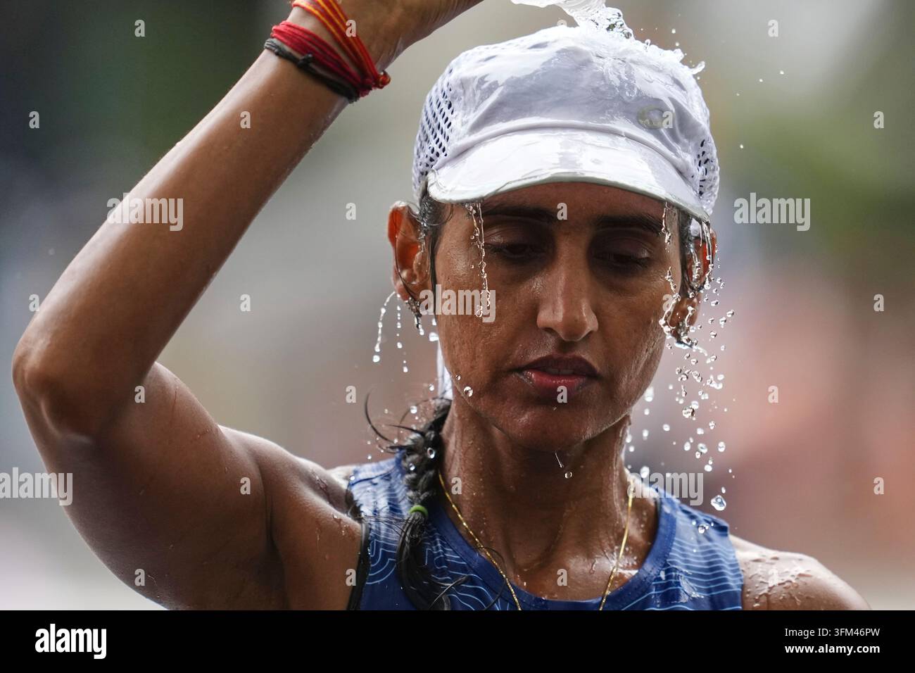 India's Manju Rani pours water over herself while competing in the ...