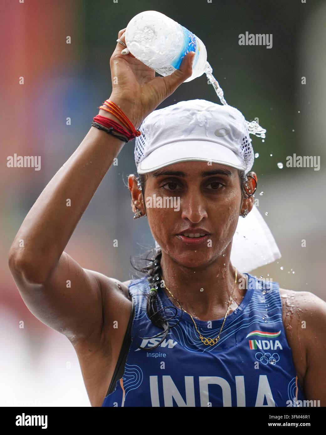 India's Manju Rani pours water over herself while competing in the ...