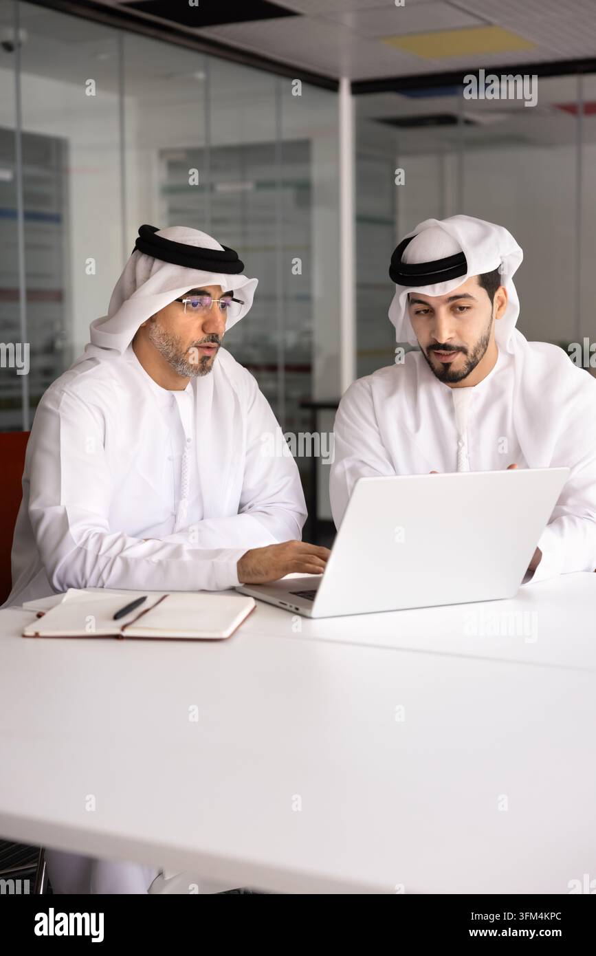 Middle Eastern business partners working in office using laptop Stock Photo