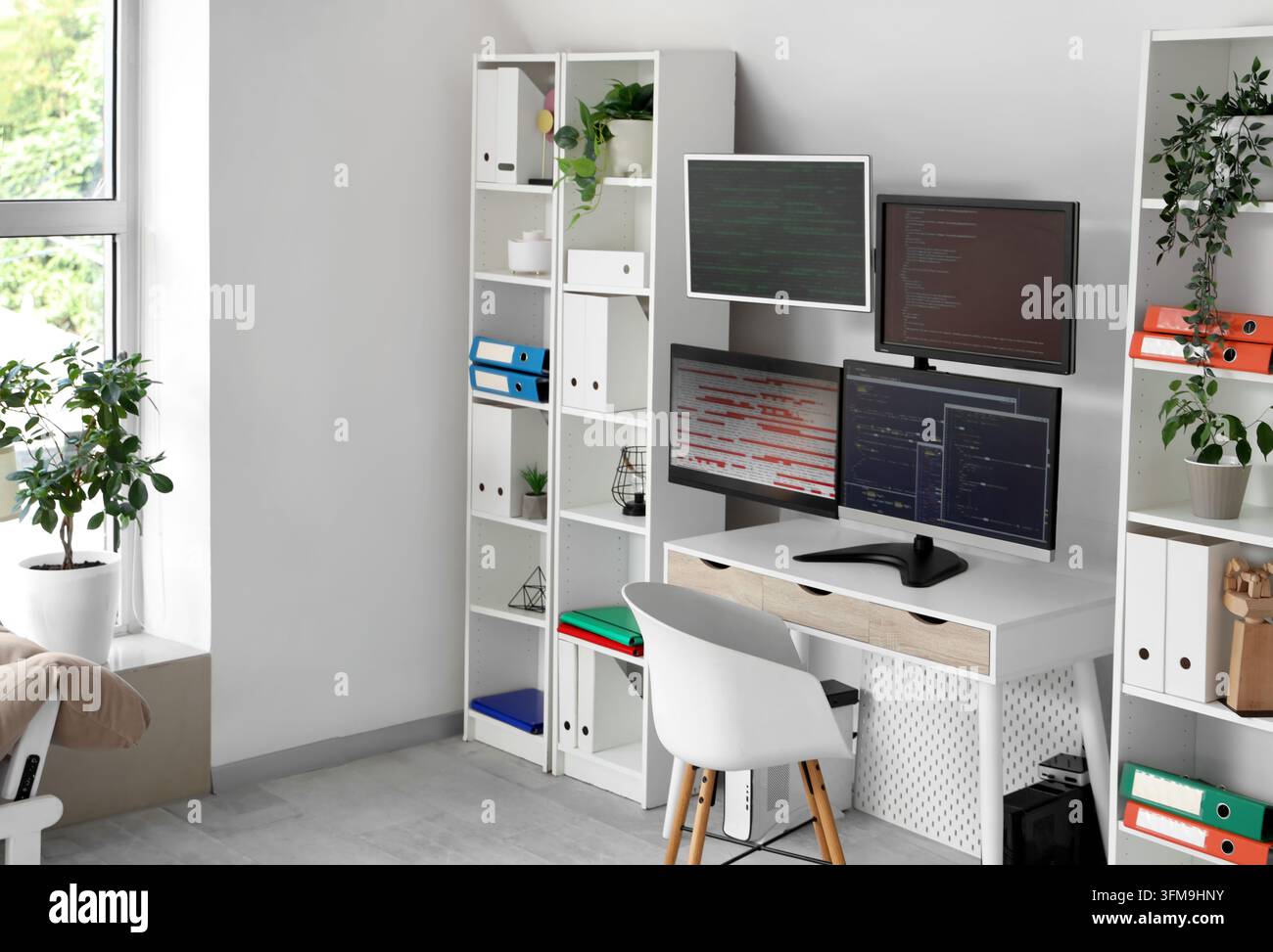 Software development and remote work, programmer home office with multiple computer monitors displaying code and data analytics in a modern workspace Stock Photo