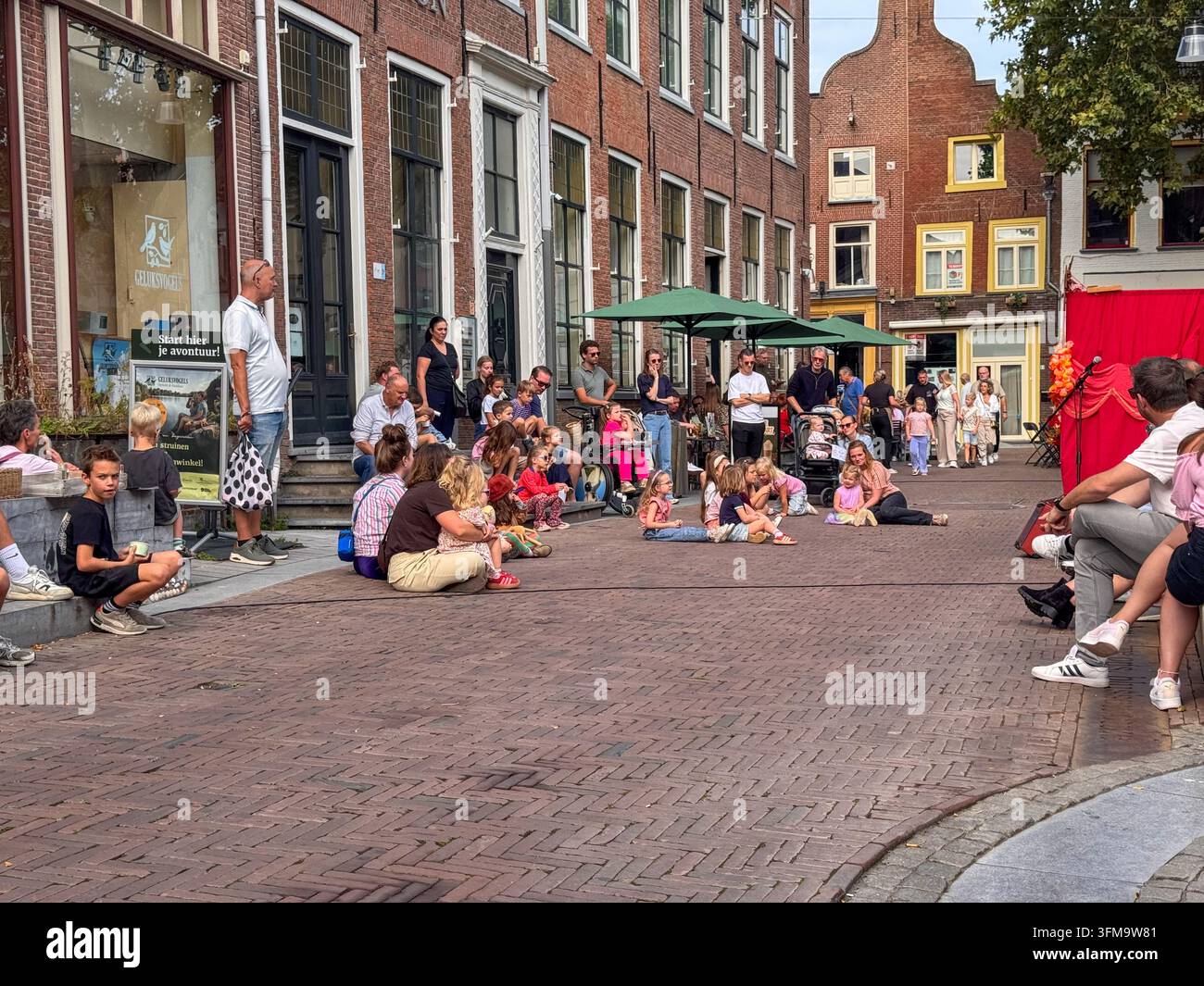 ZUTPHEN, NETHERLANDS - SEPTEMBER 27, 2026: Families and children gather on Schupstoel to watch an outdoor puppet theater performance. - Smartphone Captured Stock Image