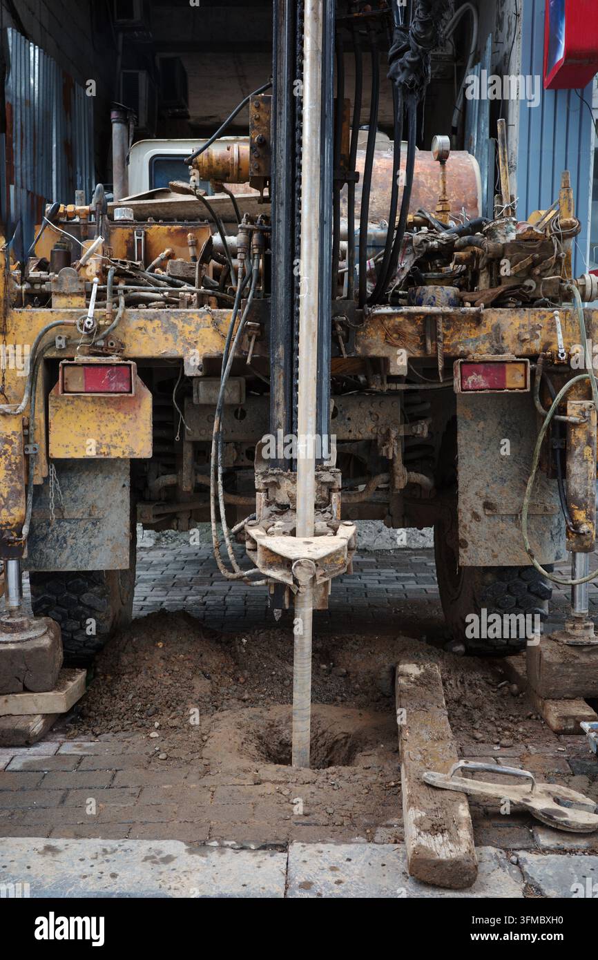 Geotechnical drilling rig borehole construction soil investigation hydraulic machinery working on urban ground for foundation testing and engineering.. Stock Photo