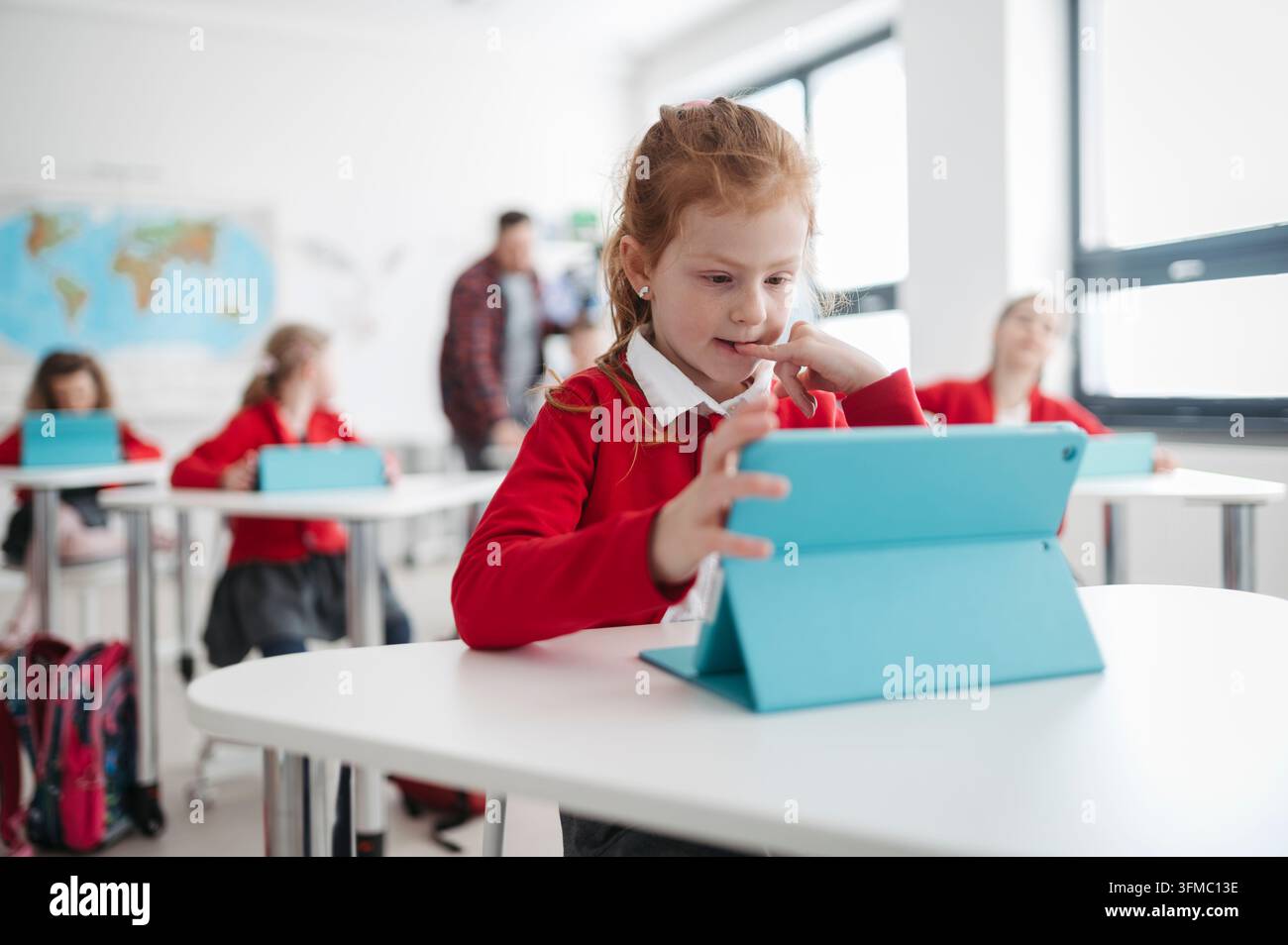 Schoolchildren using tablets and artificial intelligence tools for learning in classroom. Stock Photo