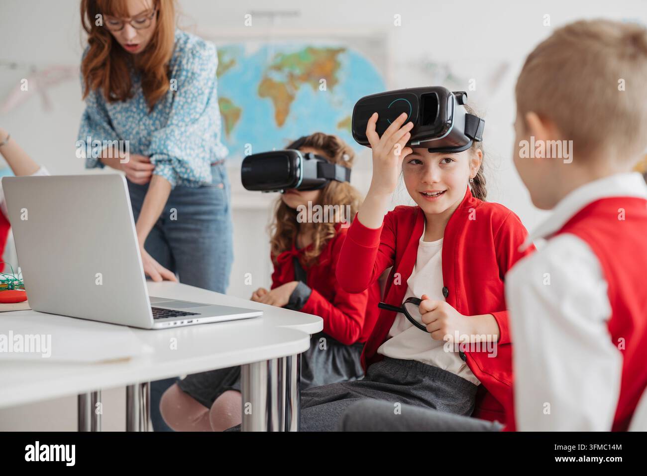 Primary school students exploring virtual reality during technology class. Stock Photo