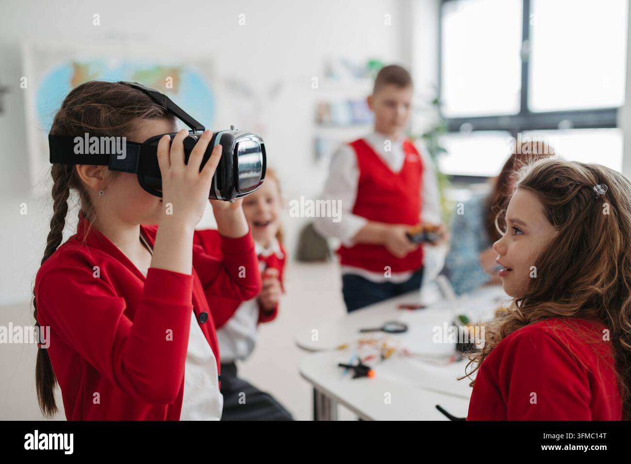Primary school students exploring virtual reality during technology class. Stock Photo