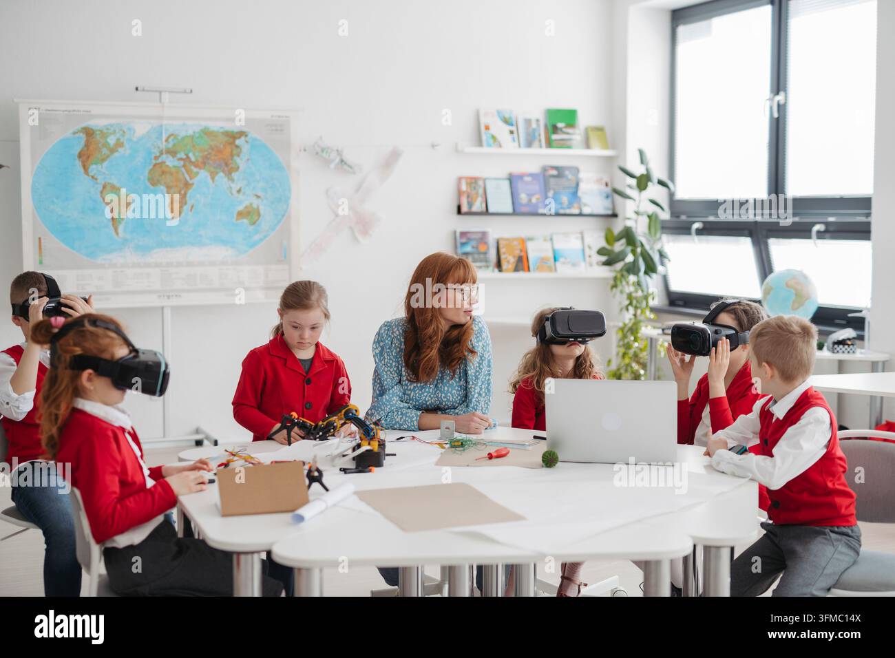 Primary school students exploring virtual reality during technology class. Stock Photo