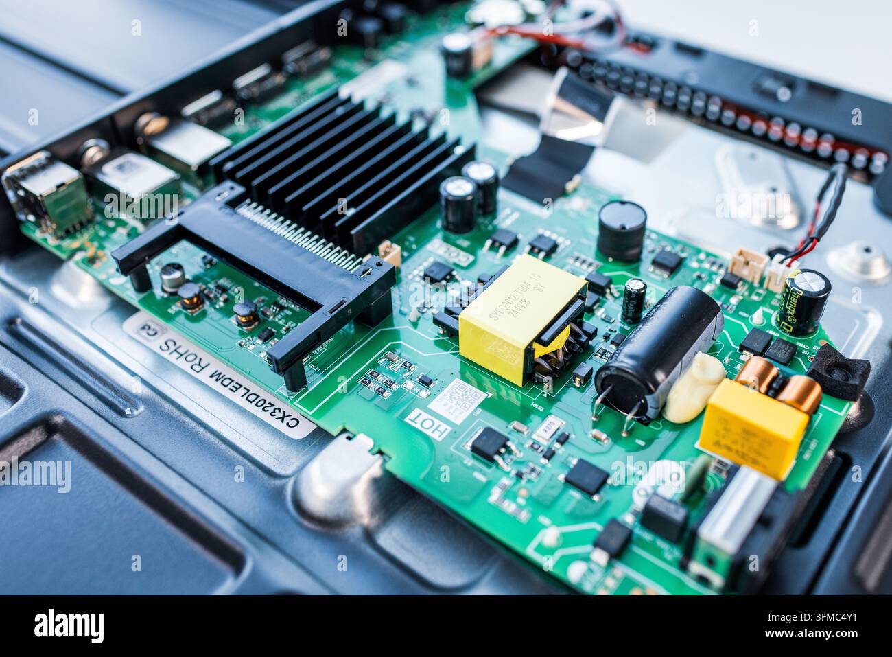 Green circuit board showing various electronic components inside a device Stock Photo