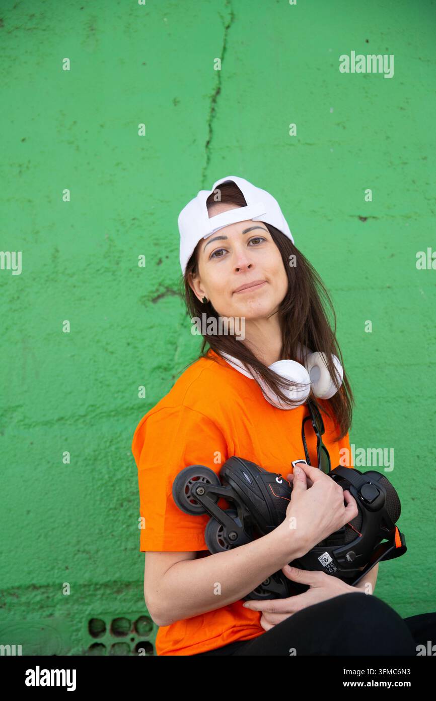 Young woman with inline skates and headphones posing Stock Photo