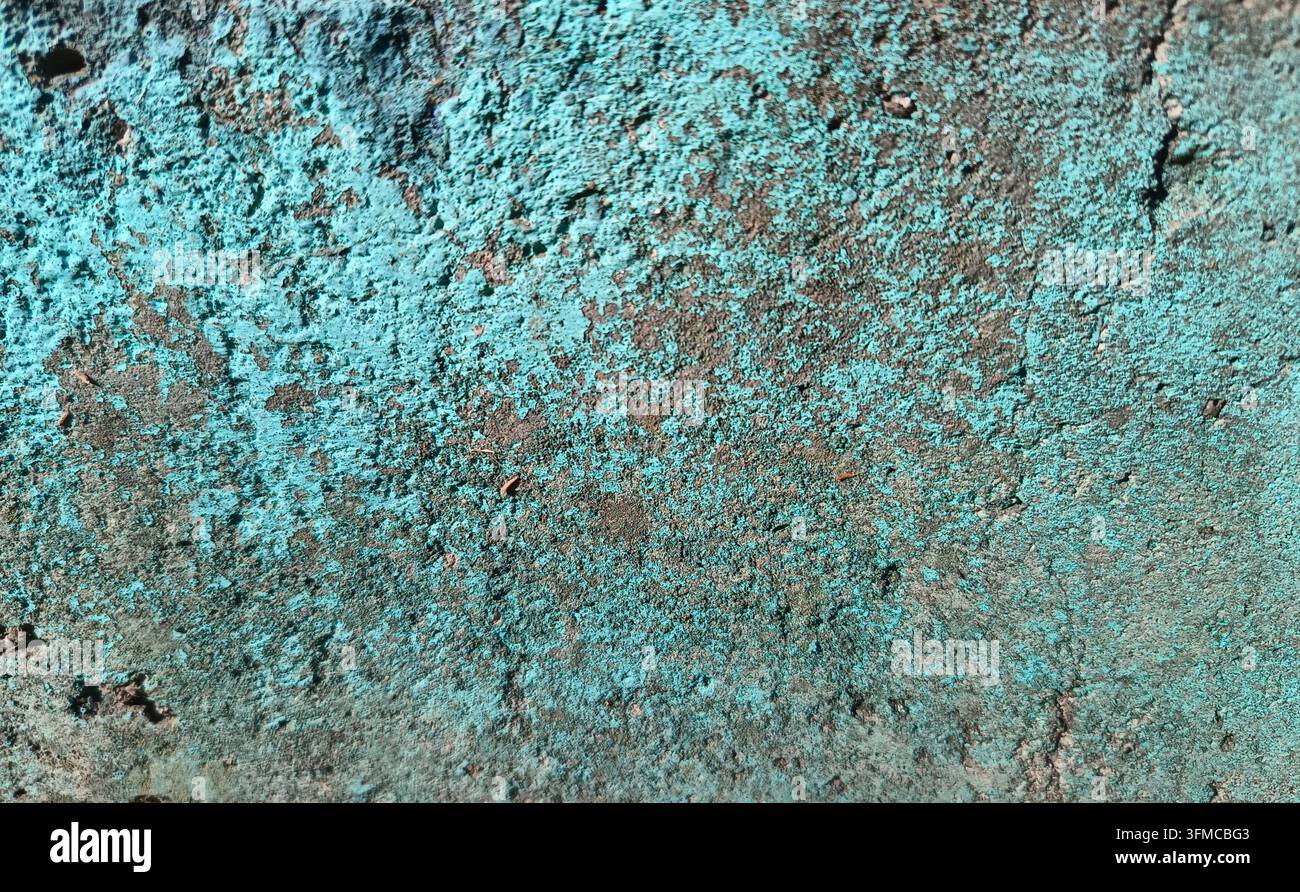 Rough concrete wall with remnants of blue paint. Stock Photo