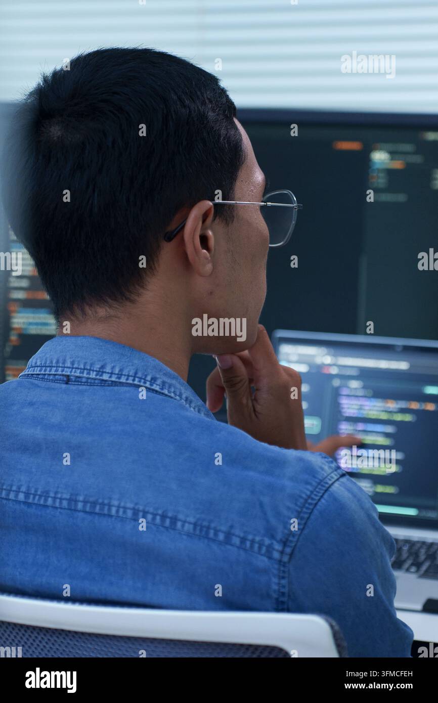 Programmer Analyzing Code on Multiple Screens Stock Photo