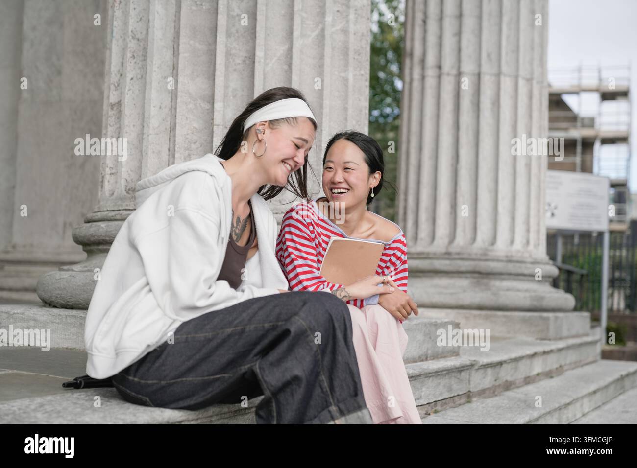 Diverse students laughing sharing moment on campus Stock Photo
