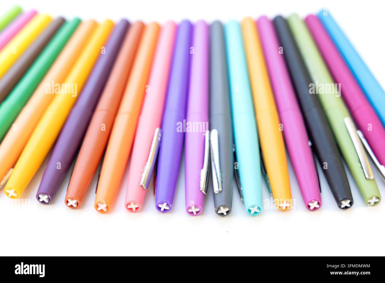 Bright colored pens lie neatly arranged on a flat surface Stock Photo