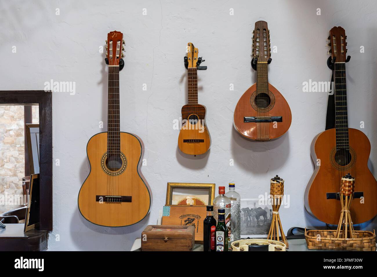 FUERTEVENTURA, SPAIN – AUGUST 7, 2026: Traditional guitars and stringed instruments mounted on a white wall at Finca Pepe (farm). Stock Photo