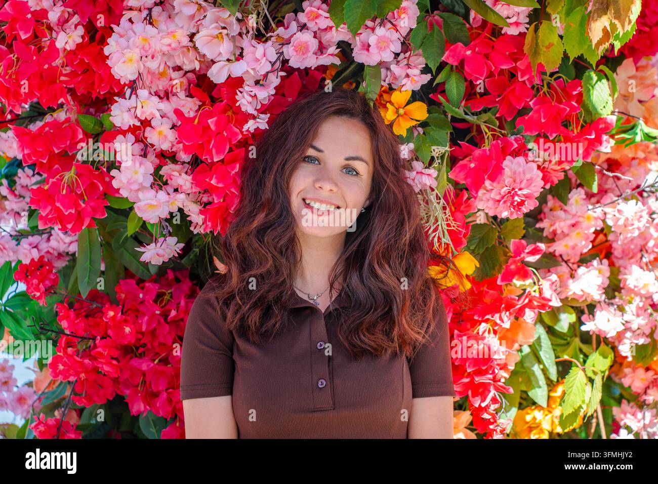 A beautiful young woman with long, wavy brown hair smiling brightly at ...