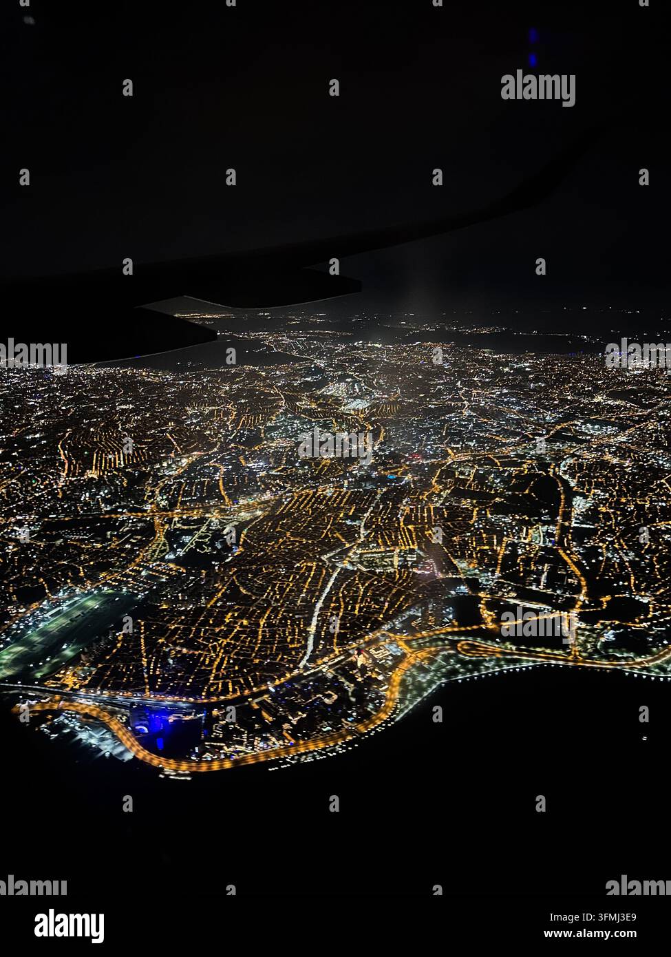 Aerial view of the night city glowing with lights from an airplane ...