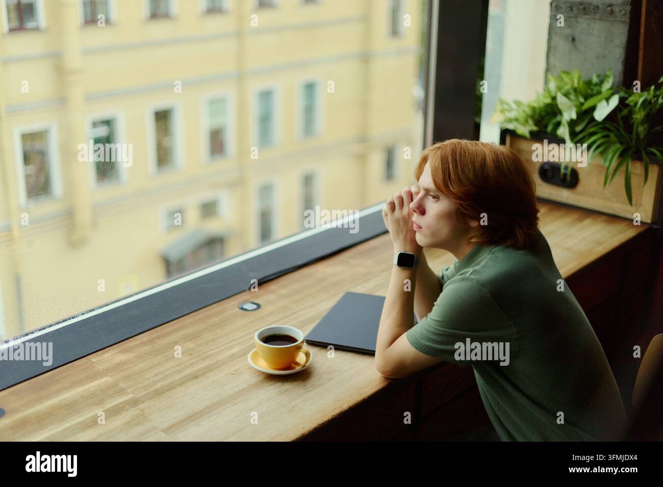 Thoughtful Man Looking through Window during Remote Work Break Stock Photo