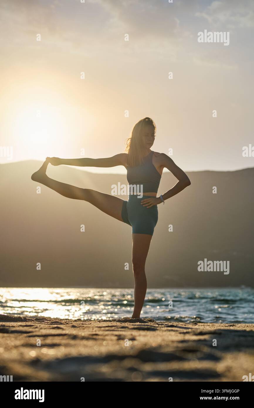 In backlit Utthita Hasta Padangusthasana yoga, Extended Hand-to-Big-Toe ...